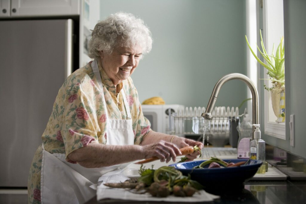17512 an elderly woman washing produce or