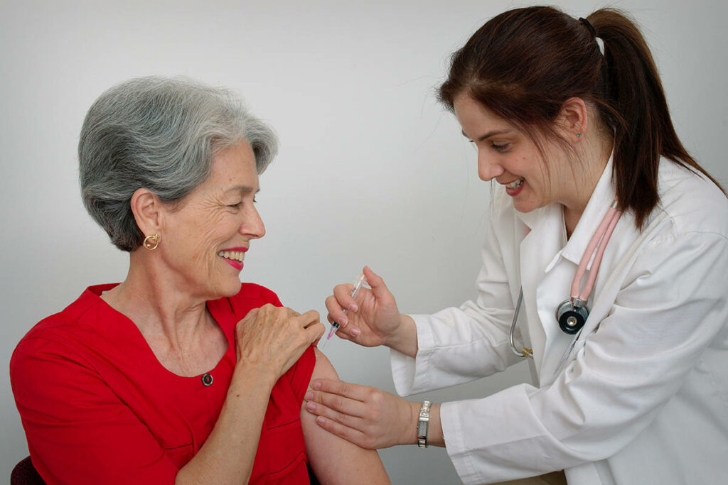 18434917 web1 15813 a senior woman receiving a vaccination shot from her doctor or