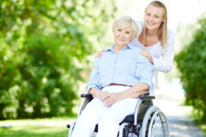 caregiver pushing senior woman wheelchair scaled